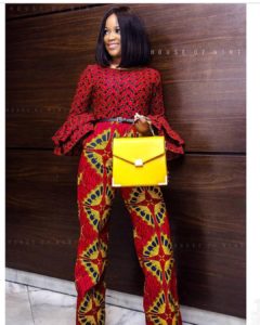 African girl in red ankara jumpsuit with yellow handbag