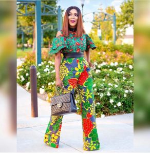 African girl in green ankara jumpsuit and floral print bottoms