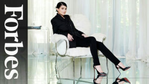 kylie jenner weafring a black suit on in a white chair