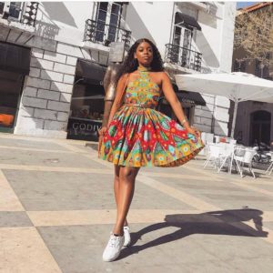 African girl in halterneck short ankara dress with white sneakers