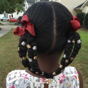 Little black girls with her natural hair styled into four conjoined pigtail braids