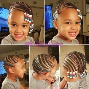 Little black girl with beautiful cornrow braids decorated with beads