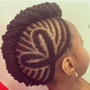 Little black girl with tiny cornrow braids forming a mowhawk, and two cornrows forming a heart shape on the side of her head.