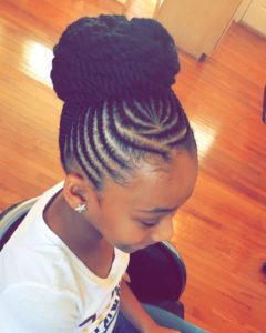 Cute little girl with her hair cornrowed into a braided updo bun