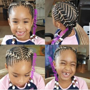Cute little girl with her hair braided into cornrows and crisscrossed with string