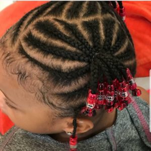 Little black girl with short cornrow braids, decorated with beads