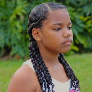 Little black girl with two flat twists ending in curly pigtails