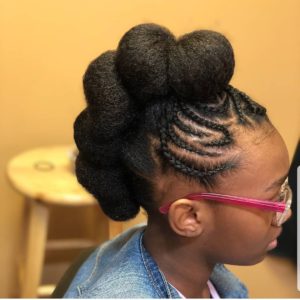 Little black girl with small cornrows in front and Mohawk buns at the back
