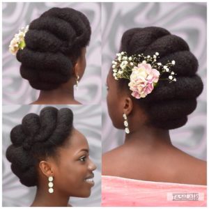 natural hair bridal hairstyle, roll tuck and pin with floral accessor