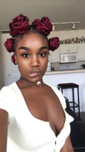 black girl wearing her wine red box braids in bantu knots style