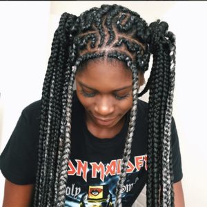 black girl wearing elaborate two-toned braids packed into pigtails