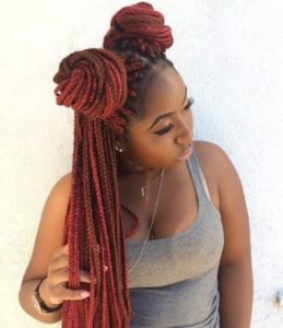 black girl with red box braids twisted into two bantu knots in half uo half down style