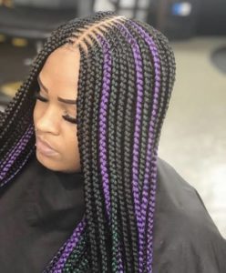 black woman wearing long braids with purple highlight