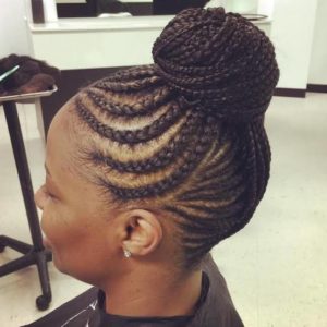 black girl with curvy cornrows leading to an updo bun