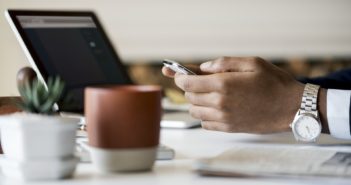 6 Ways To Make Money Online hand with mobile phone, laptop and mug