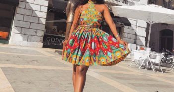 African girl in halterneck short ankara dress with white sneakers